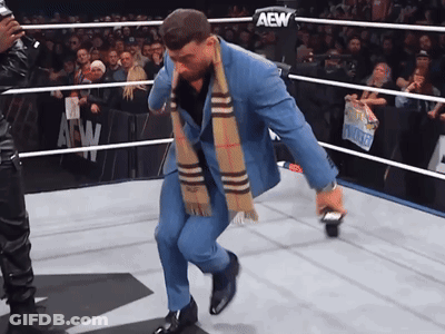 Man In Suit And Scarf In AEW Ring GIF
