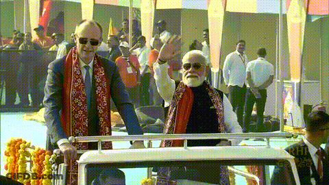 Man In Suit And Scarf Next To Bearded Man With Sunglasses GIF