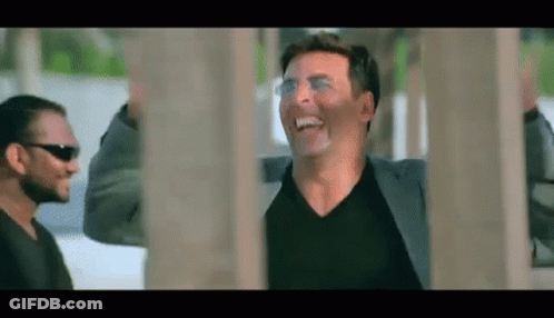 Man In Suit And Sunglasses Laughing Next To Man In Black Shirt GIF
