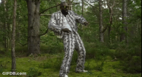 Man In Suit And Sunglasses Standing In Forest GIF
