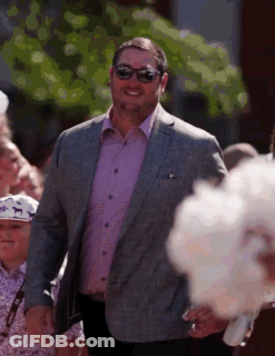 Man In Suit And Sunglasses Walking Before Crowd GIF