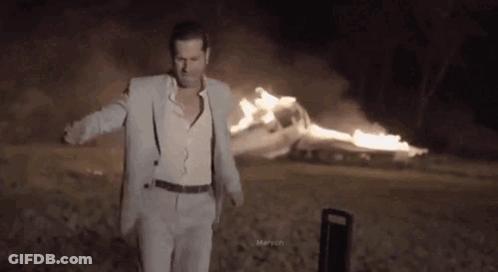 Man In Suit And Suspenders Before Burning Car GIF