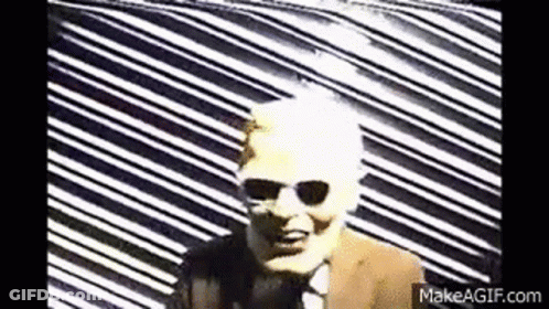 Man In Suit And Tie Against Colorful Geometric Pattern GIF