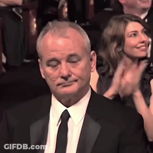 Man In Suit And Tie Applauding In Crowd GIF