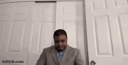 Man In Suit And Tie At Closet Door GIF