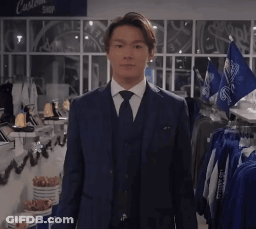 Man In Suit And Tie At Custom Shop Sign GIF