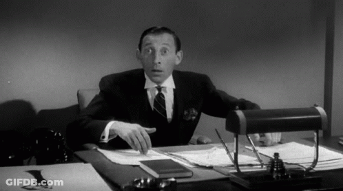 Man In Suit And Tie At Desk With Papers GIF