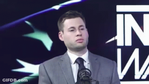 Man In Suit And Tie At Microphone Saying In GIF