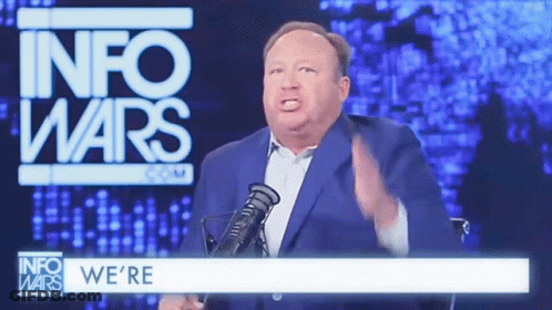 Man In Suit And Tie At Microphone With M GIF