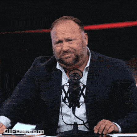 Man In Suit And Tie At Microphone With X GIF