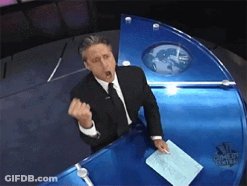 Man In Suit And Tie At NBC Comedy Central News Desk GIF