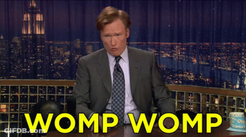 Man In Suit And Tie At Table Saying Womp Womp GIF