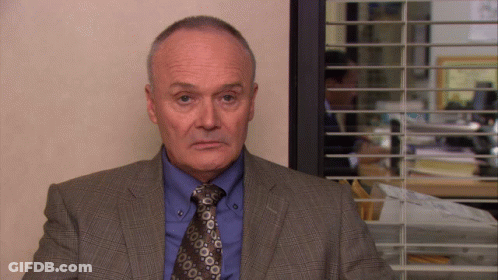 Man In Suit And Tie At Window With Blinds GIF