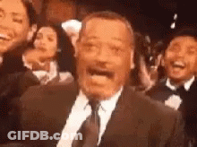 Man In Suit And Tie Before Laughing Crowd GIF