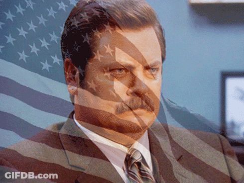 Man In Suit And Tie Behind American Flag GIF