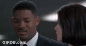 Man In Suit And Tie Beside Woman In White Shirt GIF