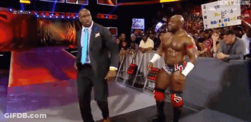 Man In Suit And Tie Beside Wrestler GIF
