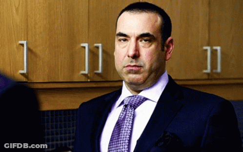 Man In Suit And Tie By Cabinets Number 11 GIF