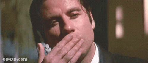 Man In Suit And Tie Covering Mouth On Phone GIF