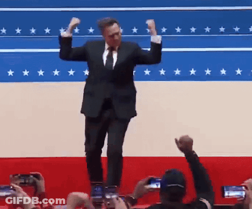 Man In Suit And Tie Dancing Before Star Flag GIF
