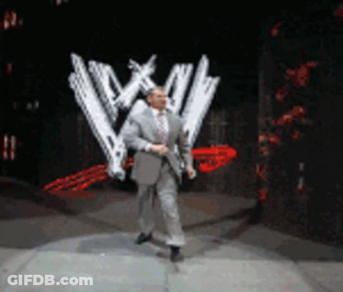 Man In Suit And Tie Dancing In Front Of WWE Logo GIF
