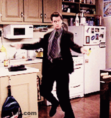 Man In Suit And Tie Dancing In Kitchen In Front Of Refrigerator GIF