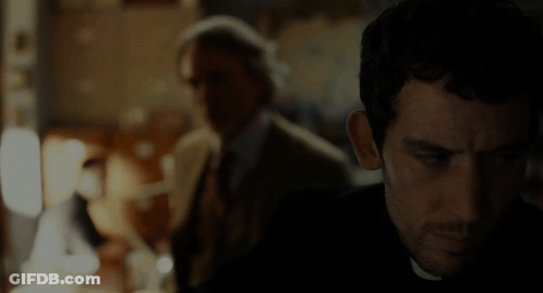 Man In Suit And Tie Eyes Closed In Dark Room GIF