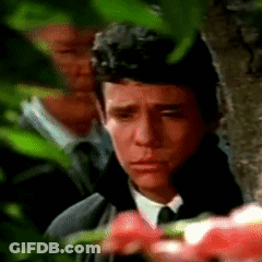 Man In Suit And Tie Eyes Closed In Front Of Tree GIF