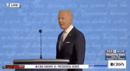 Man In Suit And Tie Giving Speech At Podium In Front Of Wall Of Text GIF