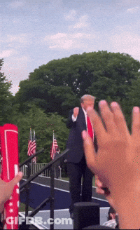 Man In Suit And Tie Giving Thumbs Up On Stage GIF
