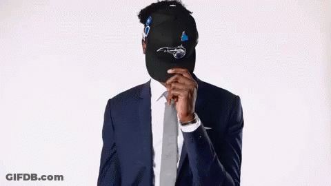 Man In Suit And Tie Hiding Face Behind Hat GIF