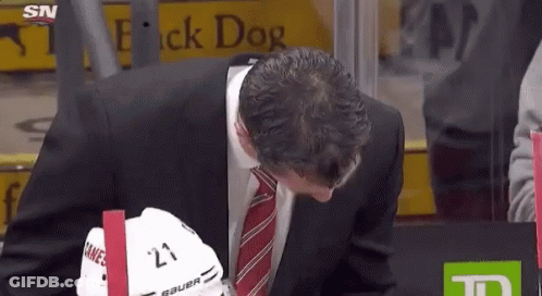 Man In Suit And Tie Holding Bauer Hockey Helmet GIF