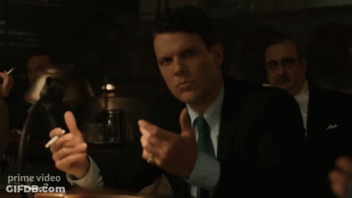 Man In Suit And Tie Holding Cigarette At Prime Video Sign GIF