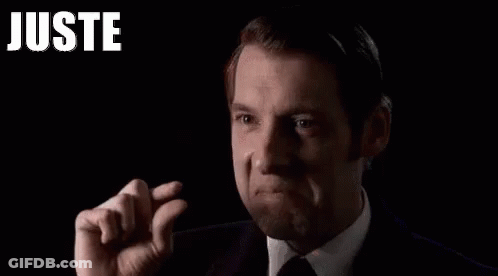 Man In Suit And Tie Holding Finger To Forehead GIF