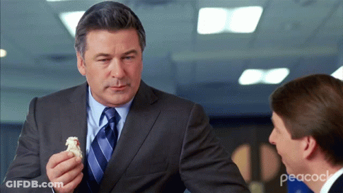Man In Suit And Tie Holding Food GIF