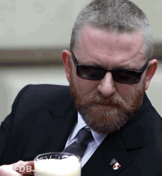 Man In Suit And Tie Holding Glass Of Milk GIF