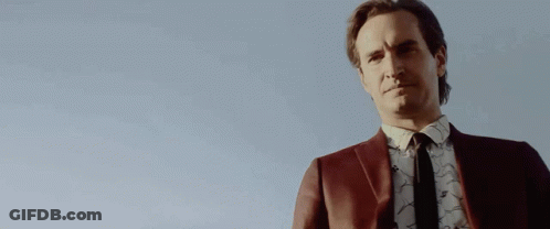 Man In Suit And Tie Holding Gun GIF