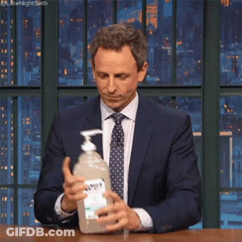 Man In Suit And Tie Holding Hand Sanitizer GIF