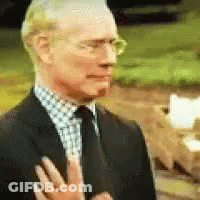 Man In Suit And Tie Holding Hand To Chest GIF