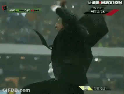 Man In Suit And Tie Holding Head On Soccer Field GIF