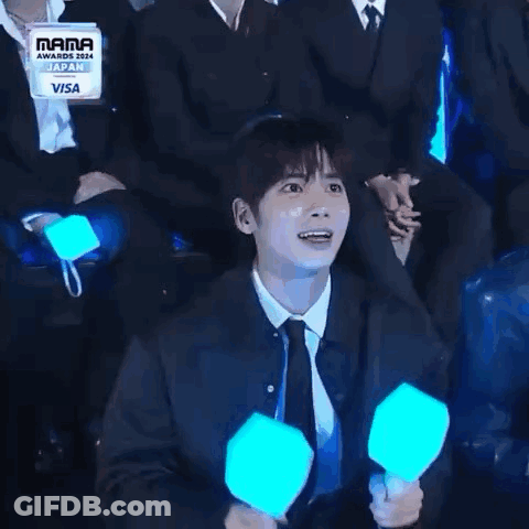 Man In Suit And Tie Holding Light Stick Laughing GIF