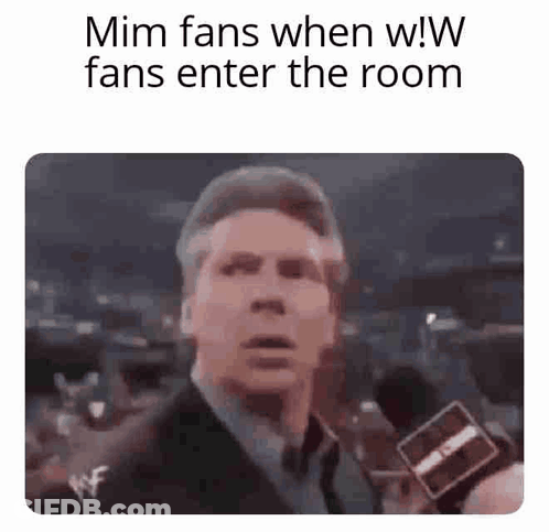 Man In Suit And Tie Holding Microphone To Crowd GIF