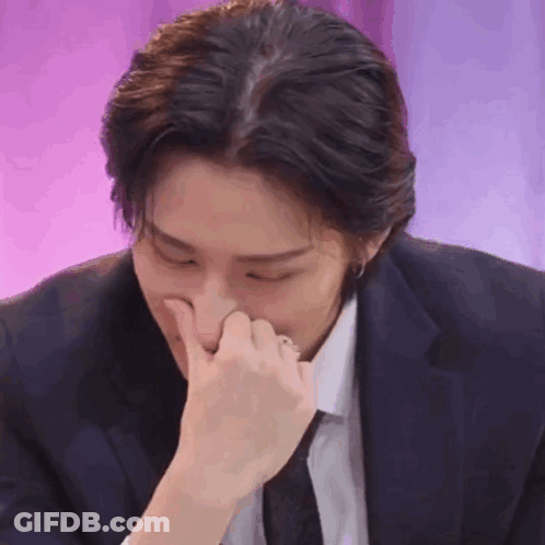 Man In Suit And Tie Holding Nose GIF
