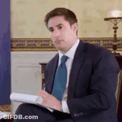 Man In Suit And Tie Holding Paper And Pen GIF