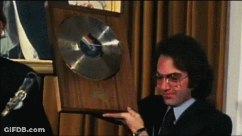 Man In Suit And Tie Holding Plaque With Record GIF