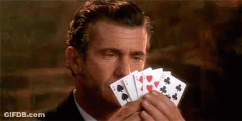 Man In Suit And Tie Holding Playing Cards To Face GIF