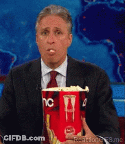 Man In Suit And Tie Holding Popcorn GIF