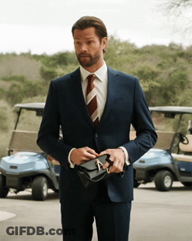 Man In Suit And Tie Holding Purse GIF