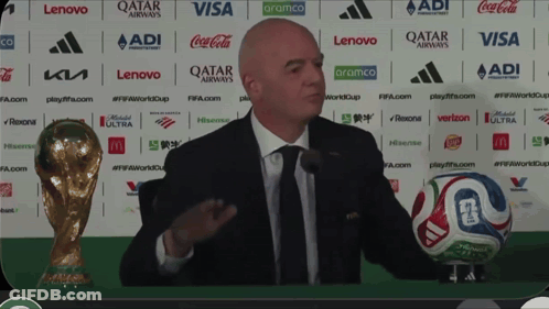 Man In Suit And Tie Holding Soccer Ball At Qatar Airways GIF