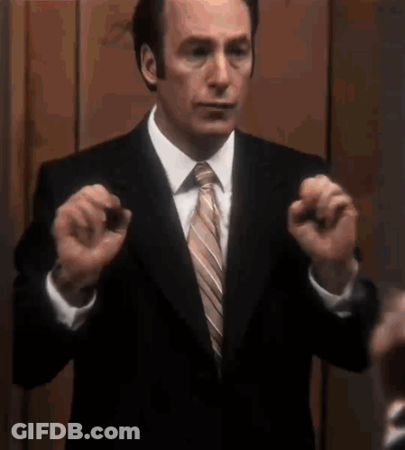 Man In Suit And Tie Holding Something GIF